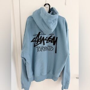 Stussy Toronto Graphic Hoodie in Light Blue with Black Logo